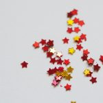 small red and gold stars scattered on a light background